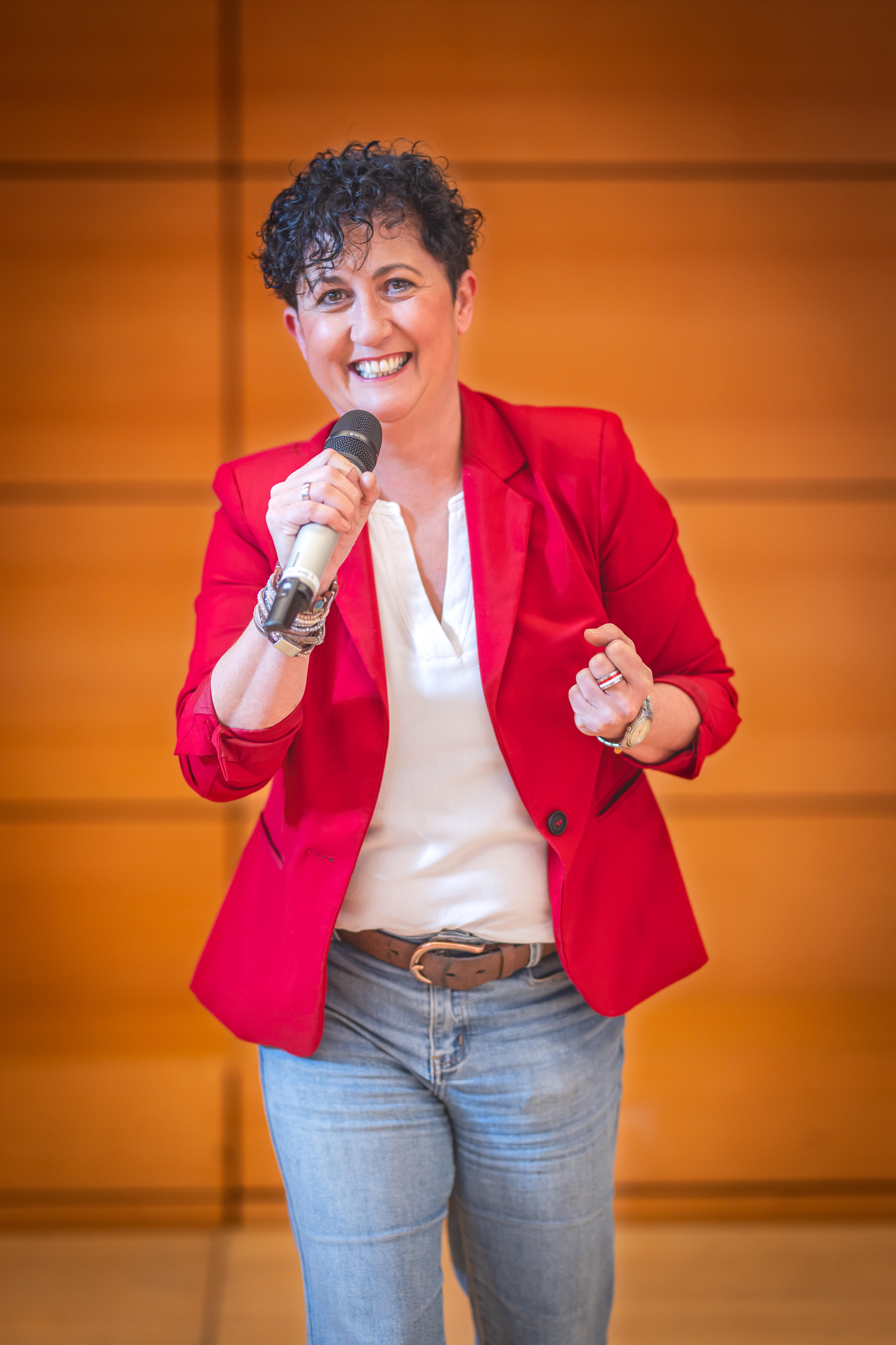 Nicole Mayer auf der Bühne mit Mikrofon.