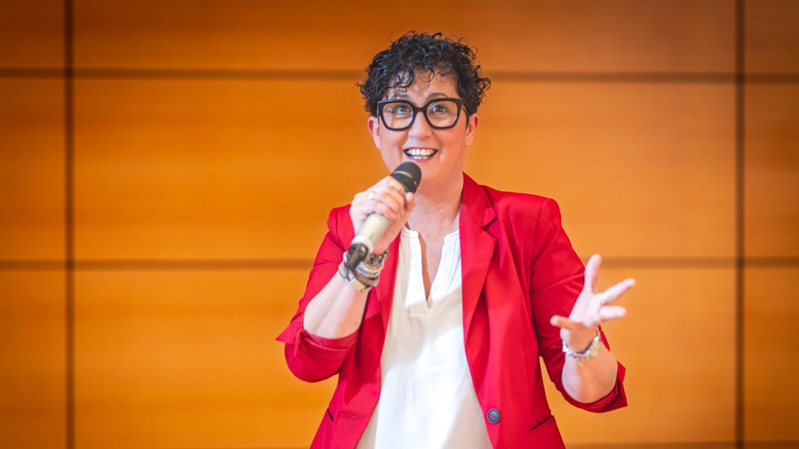 Nicole Mayer bei einem Vortrag mit Mikrofon.